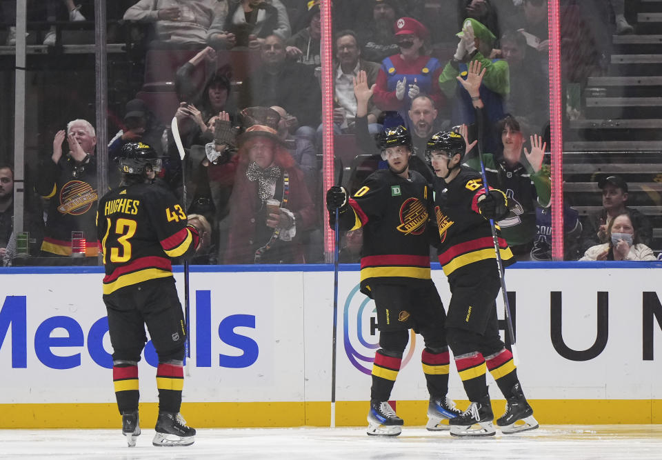 Vancouver Canucks' Quinn Hughes, Elias Pettersson and Ilya Mikheyev, from left, celebrate Pettersson's first goal against the Nashville Predators during the second period of an NHL hockey game Tuesday, Oct. 31, 2023, in Vancouver, British Columbia. (Darryl Dyck/The Canadian Press via AP)