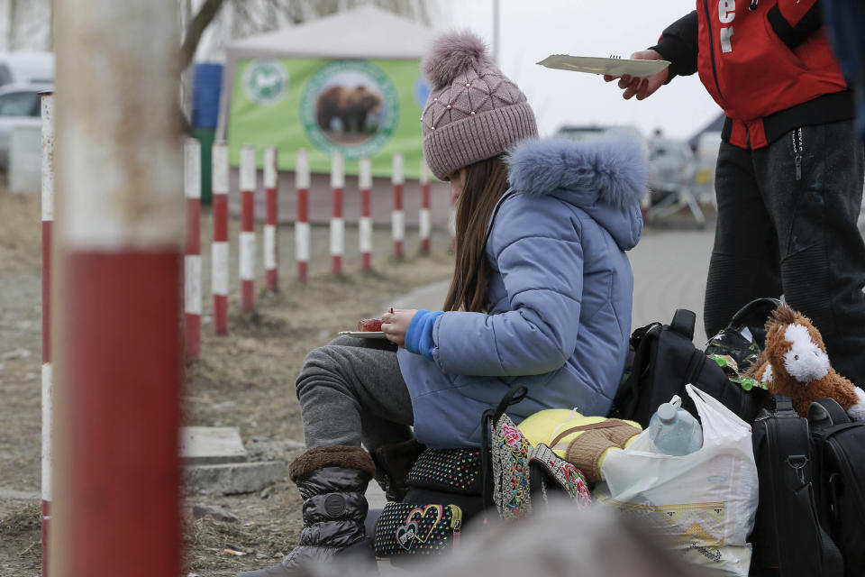 A young girl is given food, at the border crossing in Medyka, Poland, Friday, March 4, 2022. More than 1 million people have fled Ukraine following Russia's invasion in the swiftest refugee exodus in this century, the United Nations said Thursday. (AP Photo/Visar Kryeziu)