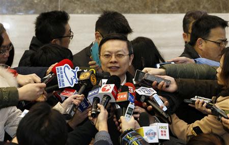 Taiwan's Mainland Affairs Chief Wang Yu-chi (C) is surrounded by microphones and recorders as he talks to journalists at the Shanghai Media Group headquarters in Shanghai, February 13, 2014. REUTERS/China Daily