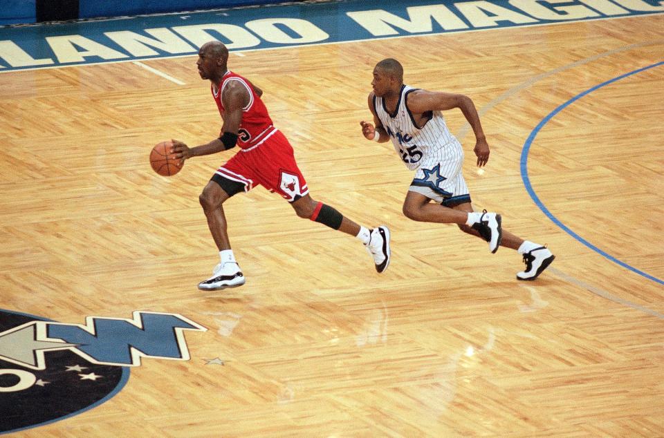 Orlando Magic guard Nick Anderson trails Michael Jordan late in the fourth quarter of a game in Orlando, Florida, on May 7, 1995.