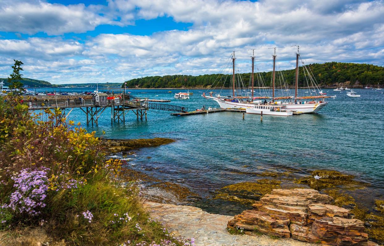 Rocky coast with boats in the harbor of Bar Harbor, Maine, on a sunny summer day