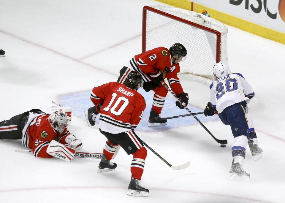 Chicago Blackhawks defenseman Duncan Keith (2) keeps St. Louis Blues left wing Alexander Steen (20) from getting a shot on goal as goalie Corey Crawford (50) and Patrick Sharp watch during the first period in Game 3 of a first-round NHL hockey Stanley Cup playoff series game Monday, April 21, 2014, in Chicago. (AP Photo/Charles Rex Arbogast)