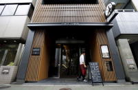 A man walks near the entrance of First Cabin hotel, which was converted from an old office building, in Tokyo, July 3, 2015. REUTERS/Toru Hanai