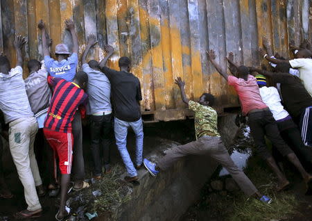 Protesters push a metal container to set up a barricade in Bujumbura, Burundi May 9, 2015. REUTERS/Goran Tomasevic