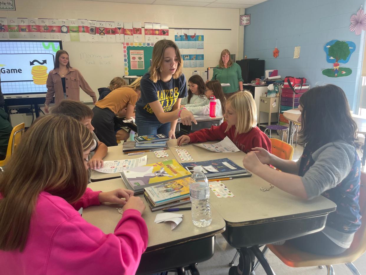 Marine City High School senior Tori Simons sets up a financial management game for Belle River Elementary School fifth graders on Oct. 12, 2023.