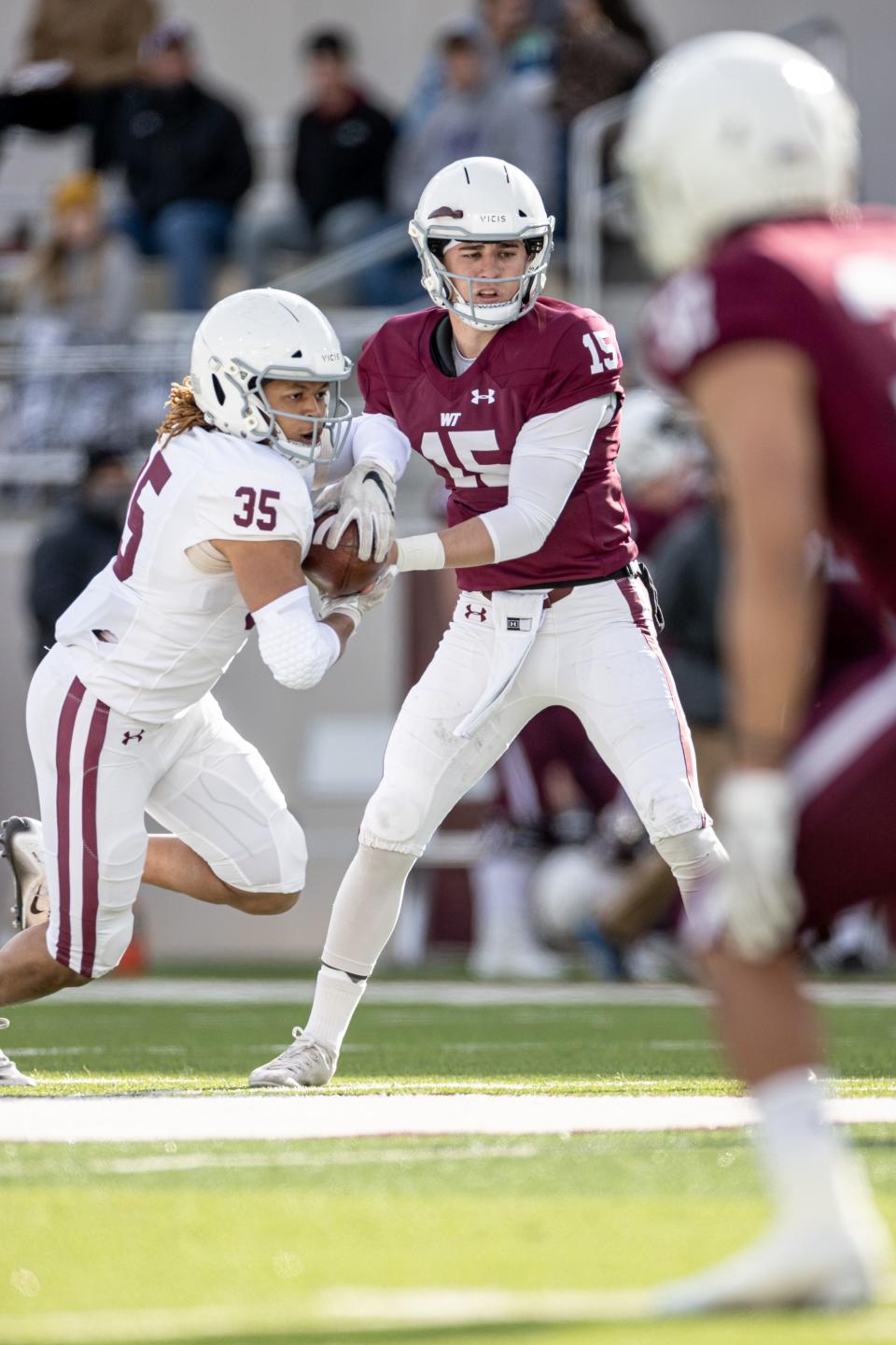 West Texas A&M's quarterback (15), Nick Gerber, hands the ball off on April 17, 2021 at Buffalo Stadium in Canyon, TX.