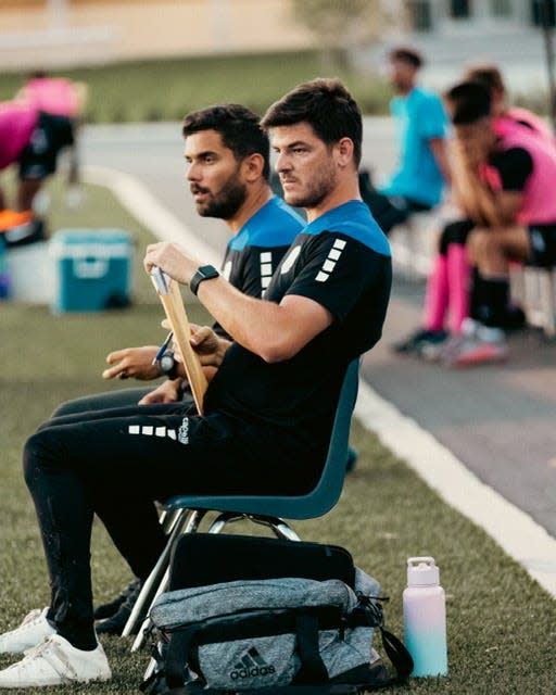 Lakeland United coach Tauan Salgado, front, and coach Erich Leite watch the action during a 2022 contest earlier this season. The United beat Florida in the first round of the UPSL Florida West playoffs.