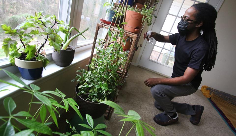 Gaston College student Lyn Holland waters the plants in his apartment on Loblolly PineDrive in Gastonia, North Carolina. The local housing authority, which issued Holland’s voucher, cut his benefits last year. Officials told Holland this spring he would have to move or pay $200 more a month in rent because he did not qualify for a two-bedroom apartment.