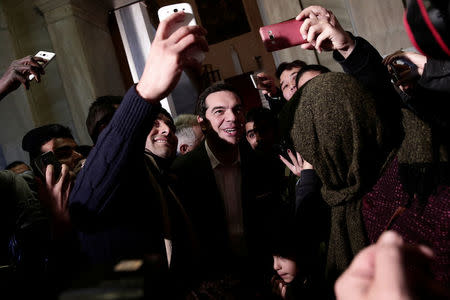 FILE PHOTO: Greek Prime Minister Alexis Tsipras takes selfies with refugee families and unaccompanied refugee minors at the parliament building in Athens, Greece, December 22, 2016. REUTERS/Alkis Konstantinidis/File Photo