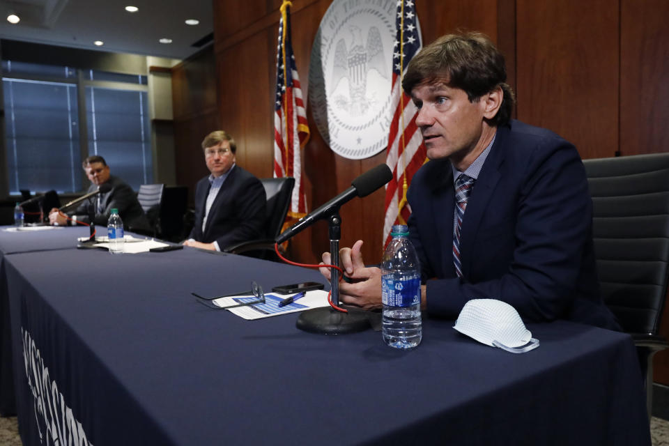 Mississippi State Health Officer Dr. Thomas Dobbs, right, expresses his concern about the growing number of positive COVID-19 tests and the lack of public face masking, while Gov. Tate Reeves, center, and Stephen McRaney, deputy director of the Mississippi Emergency Management Agency, left, listen, the governor's COVID-19 press briefing, in Jackson, Miss., Wednesday, July 8, 2020. The three public officials provided reporters with an update on the coronavirus and the state's ongoing strategy to limit transmission. (AP Photo/Rogelio V. Solis)