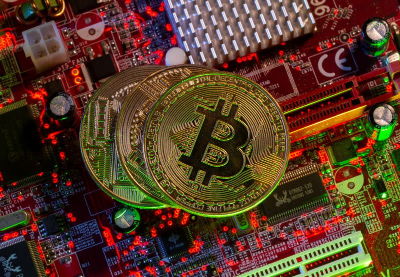 Representations of the virtual currency Bitcoin stand on a motherboard in this picture illustration