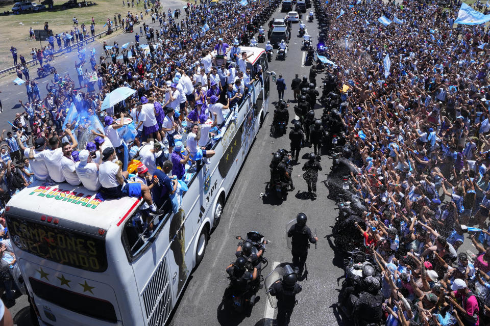 La selección argentina, incluido su capitán Lionel Messi, quien mira a la cámara, es conducida por un autobús durante un desfile por la coronación en el Mundial, el martes 20 de diciembre de 2022, en Buenos Aires (AP Foto/Natacha Pisarenko)