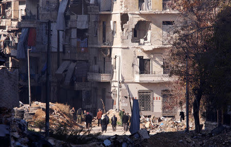 People, who evacuated the eastern districts of Aleppo, carry their belongings as they walk in a government held area of Aleppo, Syria December 9, 2016. REUTERS/Omar Sanadiki