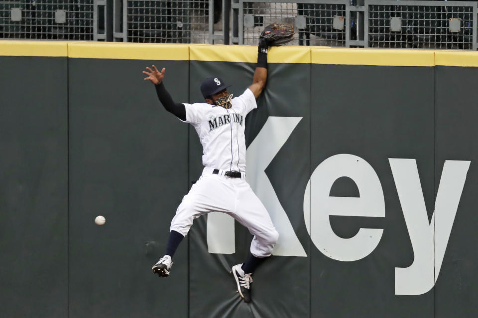 Seattle Mariners right fielder Mallex Smith hits the wall as he misses a deep fly ball from Colorado Rockies' Charlie Blackmon for a three-run double during the fifth inning of a baseball game Saturday, Aug. 8, 2020, in Seattle. (AP Photo/Elaine Thompson)