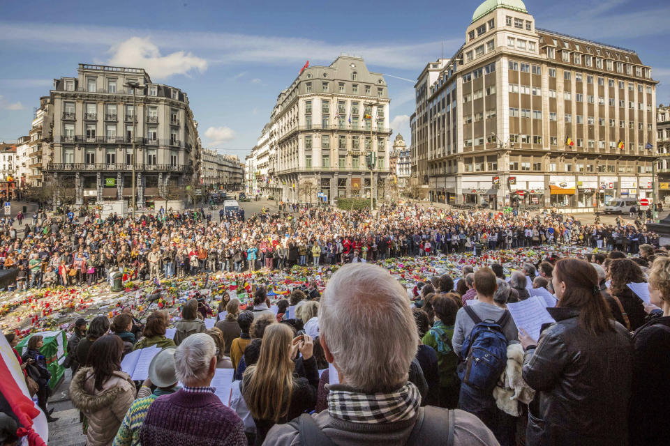 FILE - In this April 3, 2016 file photo, dozens of professional singers and a few hundred people sing famous Belgian songs at a memorial site for the victims of the Brussels attacks at the Place de la Bourse in Brussels. One year after the March 22, 2016 Brussels attacks, the city's physical scars may have healed, but the pain is still apparent beneath the surface. (AP Photo/Olivier Matthys, File)