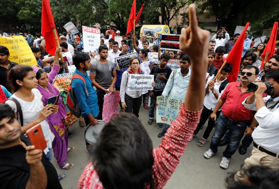 Protestors hold placards as they shout slogans