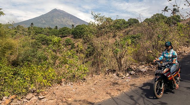 PICTURED: A tourist passing Mount Agung in Bali. Source: AAP