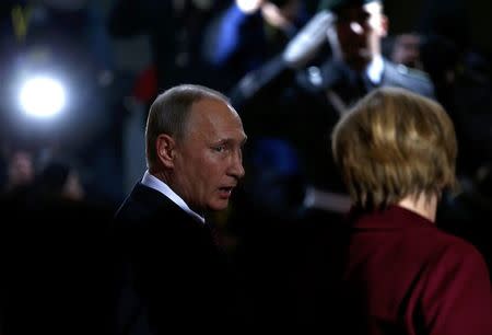 Russian President Vladimir Putin talks to German Chancellor Angela Merkel as he arrives for talks on a stalled peace plan for eastern Ukraine at the chancellery in Berlin, Germany, October 19, 2016. REUTERS/Hannibal Hanschke