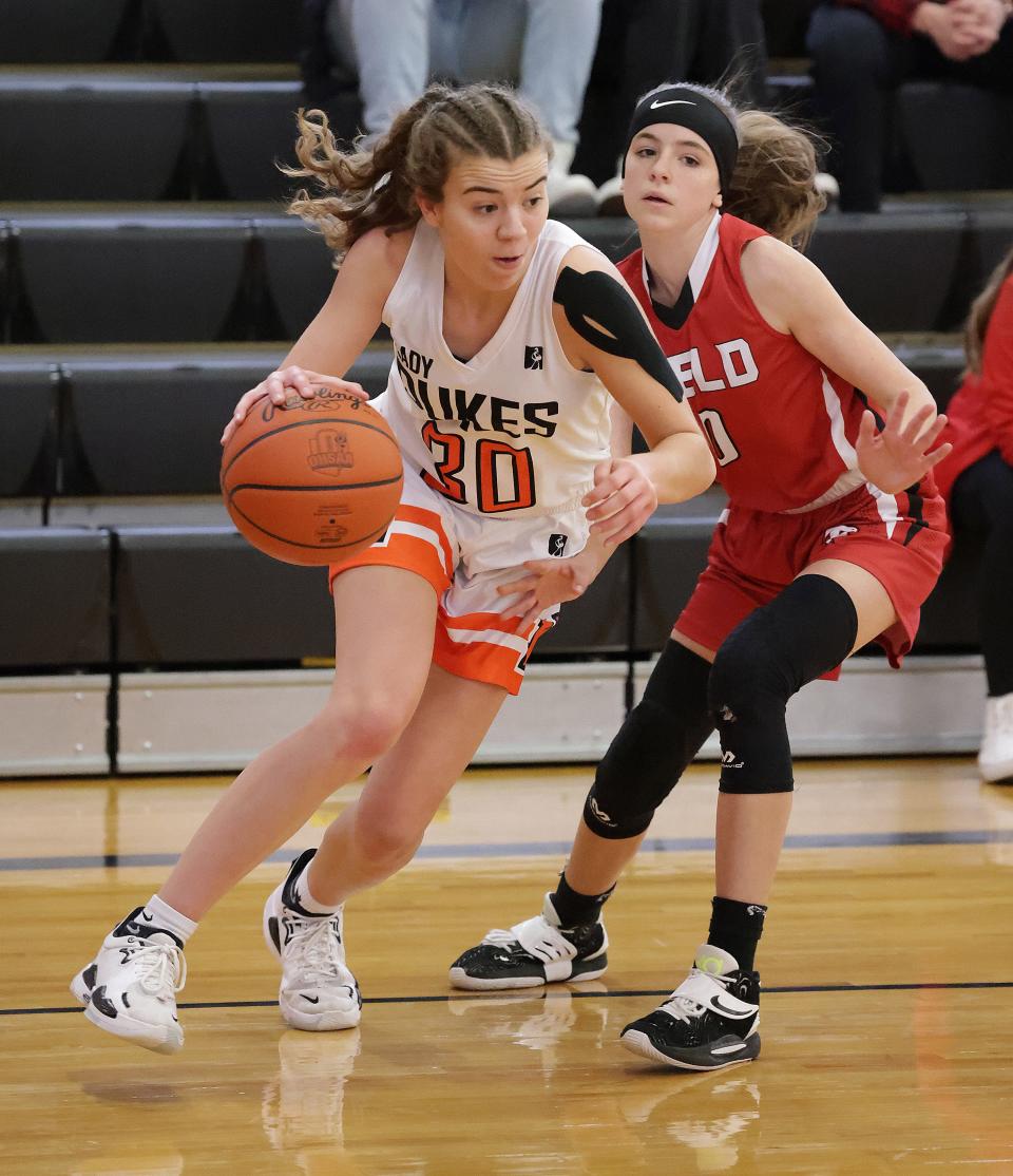 Marlington's Elizabeth Mason drives to the baskety in the first half with pressure from Field's Makayla Miller at Marlington Saturday, Feb. 19, 2022.