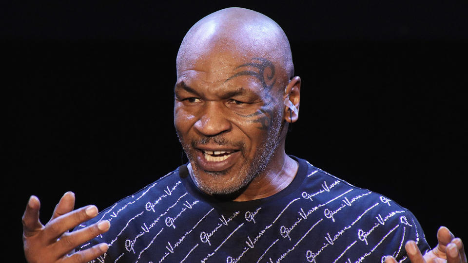 Mike Tyson speaking at a conference on stage.