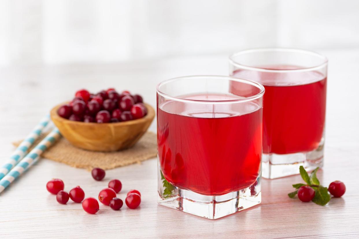Glass with fresh organic cranberry juice and red cranberries.