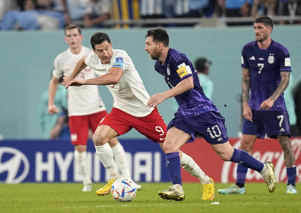 Argentina's Lionel Messi, front, duels for the ball with Poland's Robert Lewandowski during the World Cup group C soccer match between Poland and Argentina at the Stadium 974 in Doha, Qatar, Wednesday, Nov. 30, 2022. (AP Photo/Ariel Schalit)