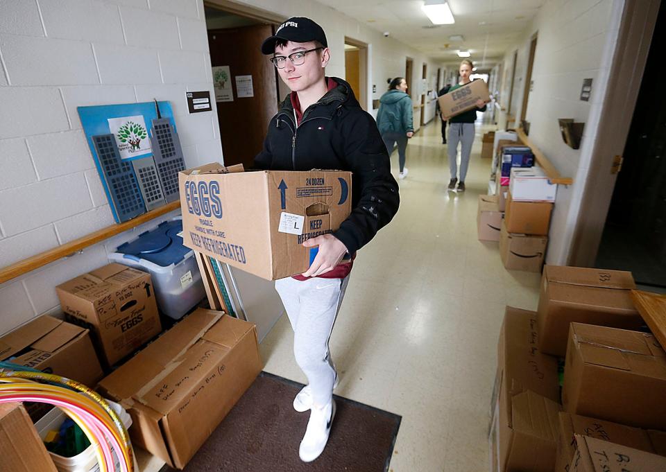 Freshman Jake Bucher and junior Ethan Wolford carry boxes out of the Ashland Parenting Plus offices in the Ashland County Service Center. The agency is moving into an office on Sandusky Street, and students were participating in AU GIVS service projects Monday