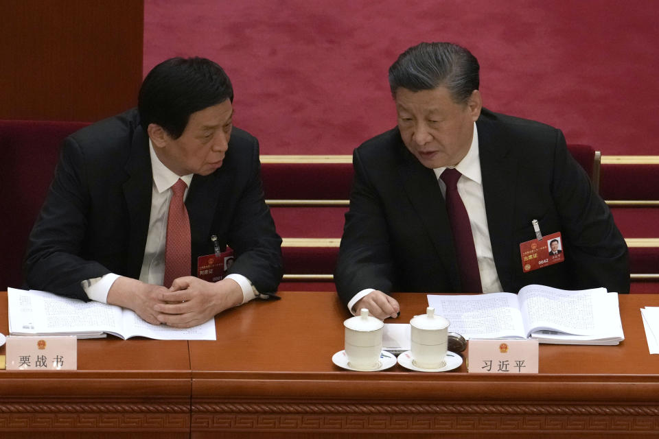 Chinese President Xi Jinping, right, and Li Zhanshu talk during the opening session of China's National People's Congress (NPC) at the Great Hall of the People in Beijing, Sunday, March 5, 2023. (AP Photo/Ng Han Guan)