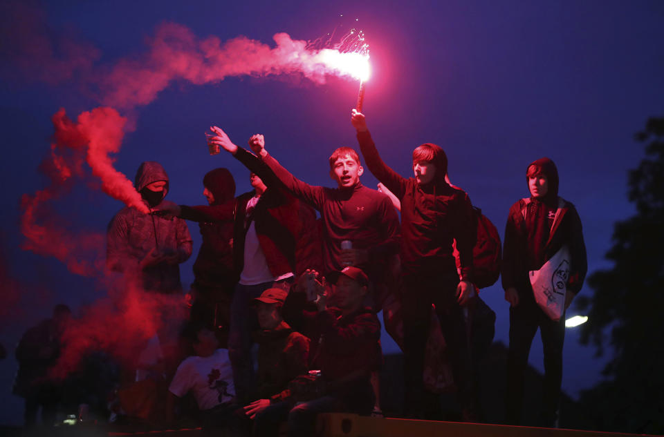 Liverpool fans celebrate outside Anfield stadium after the English Premier soccer match between Liverpool and Chelsea, Wednesday, July 22, 2020, in Liverpool, England. (Martin Rickett/PA via AP)