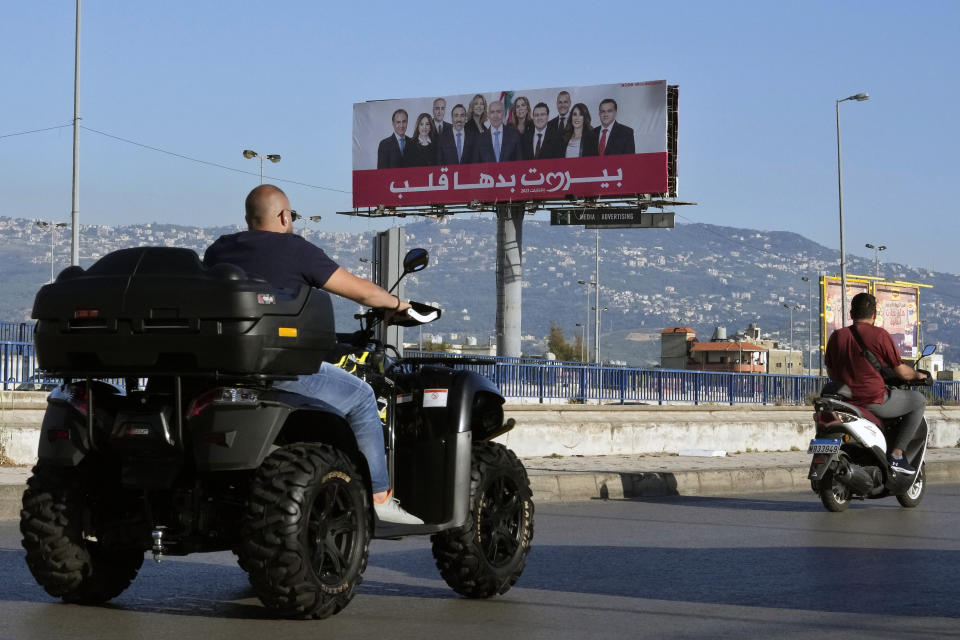 People drive past a giant electoral billboard for Lebanese Sunni billionaire Fuad Makhzoumi who is running in the upcoming parliamentary elections, in Beirut, Lebanon, Tuesday, May 10, 2022. Given Lebanon's devastating economic meltdown, Sunday's parliament election is seen as an opportunity to punish the current crop of politicians that have driven the country to the ground. (AP Photo/Bilal Hussein)