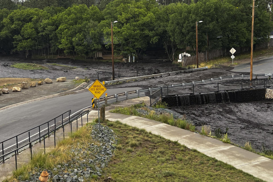 In this photo provided by the New Mexico National Guard, floodwater flows over a bridge Saturday, June 29, 2024, in Ruidoso, N.M. Most of central New Mexico remained under a flood watch into Tuesday, July 2, including Albuquerque, Santa Fe, Las Vegas and Ruidoso. (Spc. Jose Montoya/New Mexico National Guard via AP)