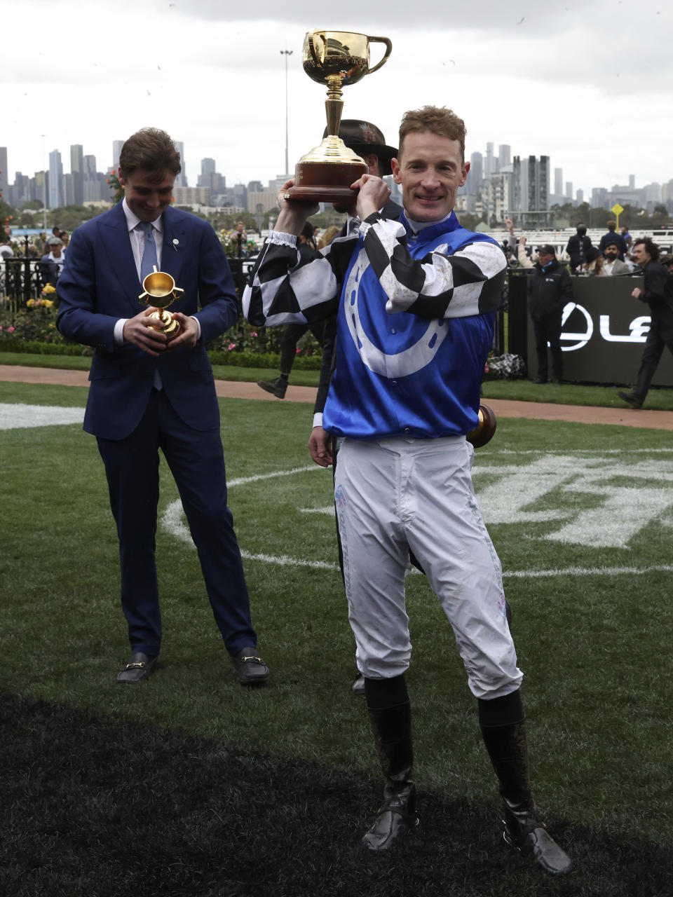 Jockey Mark Zahra, right, holds his trophy as trainer David Eustace, left, looks over his trophy after their horse Gold Trip won the Melbourne Cup horse race in Melbourne, Australia, Tuesday, Nov. 1, 2022. (AP Photo/Asanka Brendon Ratnayake)