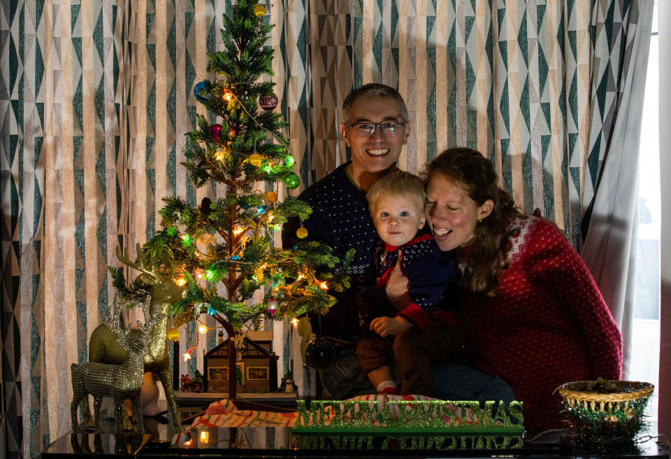 Ross Farr-Semmens and his wife Ruth, and their son Ronnie aged 20 months, alongside their christmas tree lights. (SWNS)