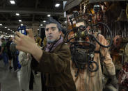 Jackson Maestas as "The War Doctor" makes a selfie with a character on the floor at the opening day of Salt Lake Comic Con, Thursday, April 17, 2014, in Salt Lake City, Utah. (AP Photo/The Salt Lake Tribune, Scott Sommerdorf)