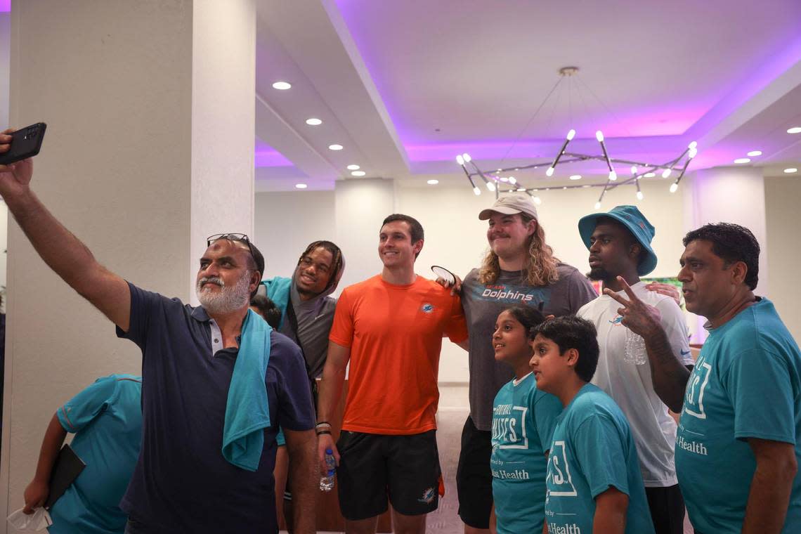 Weris Siddiqui, left, from the Islamic Center of Greater Miami, takes a selfie with some members of the Miami Dolphins rookie class during a historic walking tour of Downtown Miami with local community groups on Wednesday, June 15, 2022 beginning with tour leaders at the History Miami Museum.