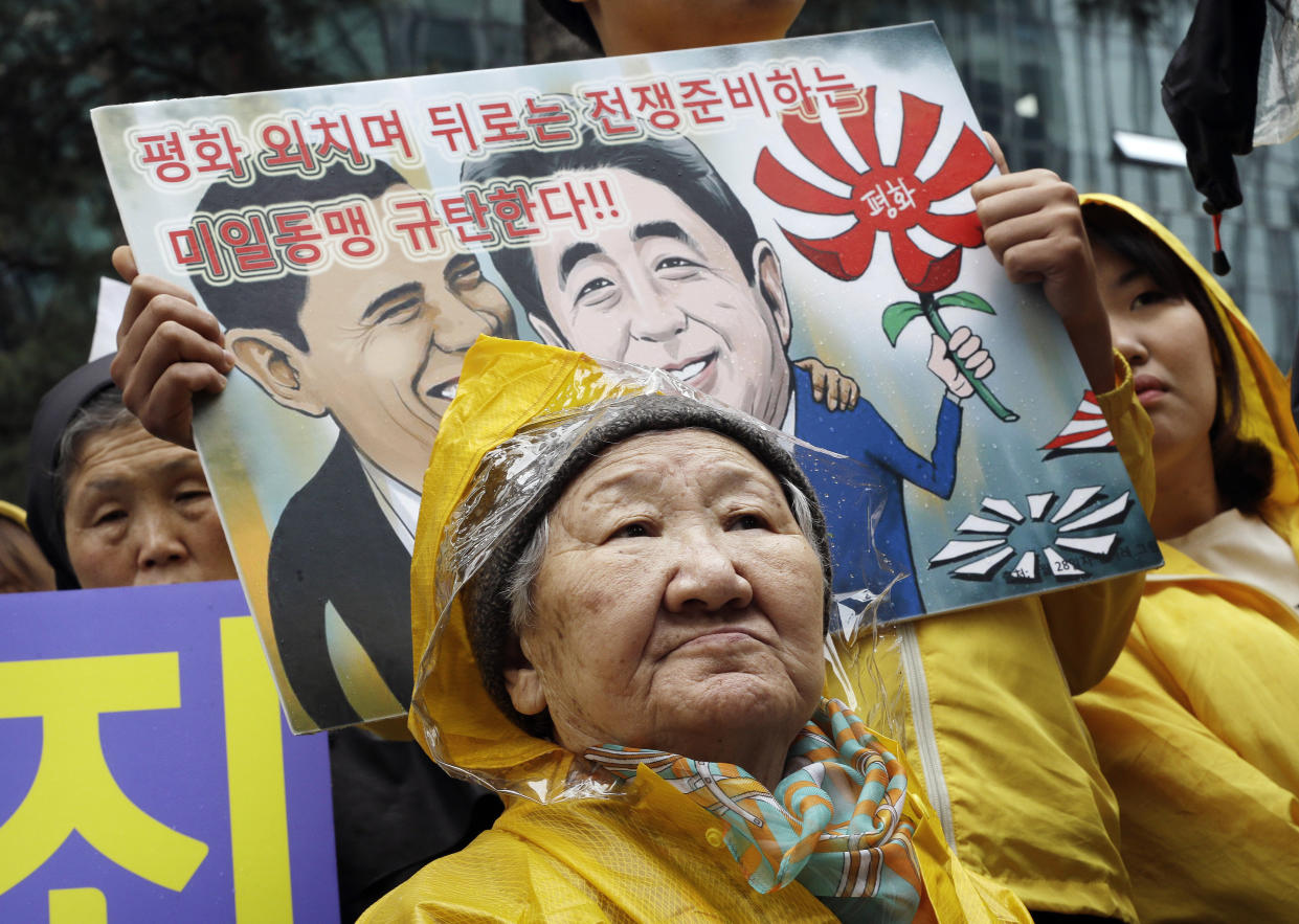 Former comfort woman Kil Un-ock who was forced to serve for the Japanese troops as a sexual slave during World War II, attends a rally against a visit by Japanese Prime Minster Shinzo Abe to the United States, in front of the Japanese Embassy in Seoul, South Korea, Wednesday, April 29, 2015. Abe has sidestepped a question on whether he would apologize for the sexual enslavement of women by Japan's army during World War II. The letters at a card read " Oppose the alliance between U.S. and Japan." (AP Photo/Ahn Young-joon)