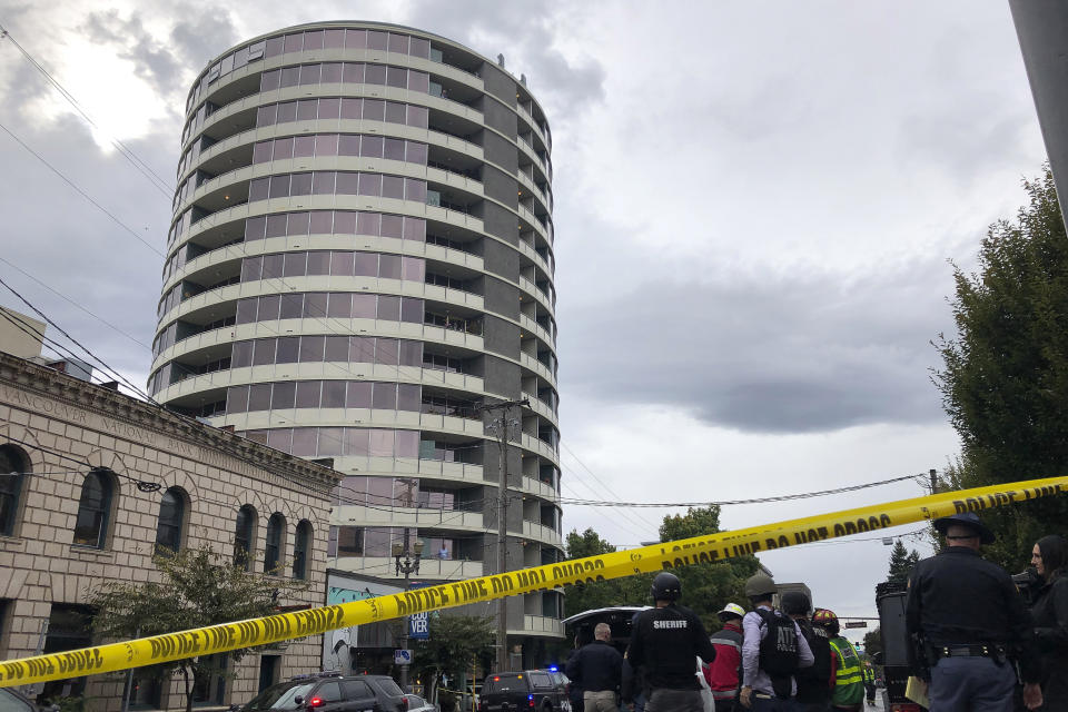 Police respond to a shooting at an apartment building, top rear, in Vancouver, Wash., Thursday, Oct. 3, 2019. Vancouver police say a resident of the building shot several people in the lobby of the Smith Tower Apartments. (AP Photo/Gillian Flaccus)
