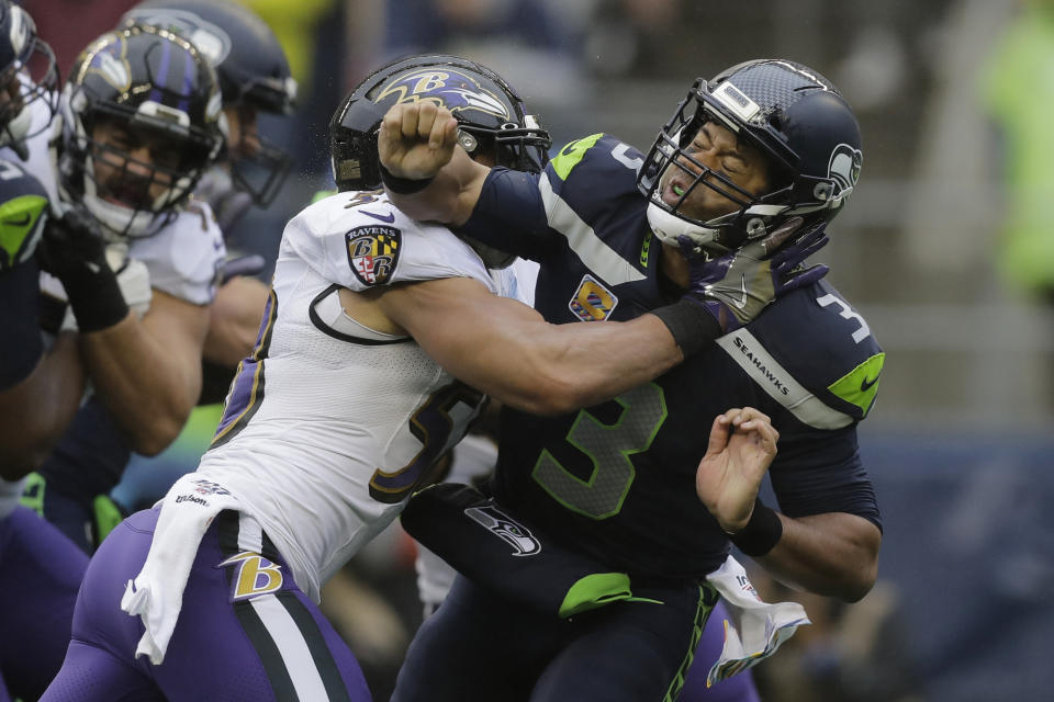 Seattle Seahawks quarterback Russell Wilson (3) is hit after he passed under pressure from Baltimore Ravens linebacker L.J. Fort, left, during the first half of an NFL football game, Sunday, Oct. 20, 2019, in Seattle. (AP Photo/John Froschauer)