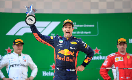 FILE PHOTO: Formula One F1 - Chinese Grand Prix - Shanghai International Circuit, Shanghai, China - April 15, 2018 Red Bull's Daniel Ricciardo celebrates with a trophy on the podium after winning the race as Mercedes' Valtteri Bottas and Ferrari's Kimi Raikkonen look on REUTERS/Aly Song