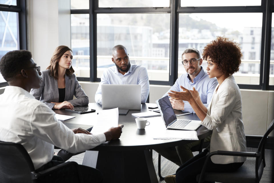 Black millennial businesswoman speaking to colleagues at a company meeting, close-up