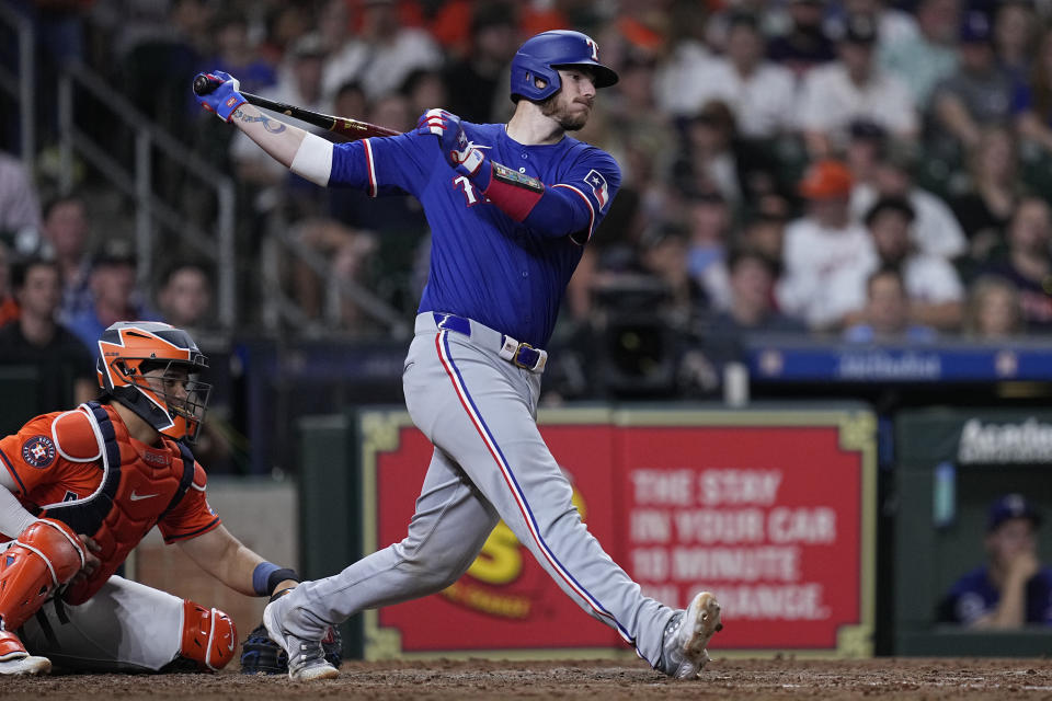 Texas Rangers' Jonah Heim drives in Adolis García during the sixth inning of a baseball game against the Houston Astros Friday, April 12, 2024, in Houston. (AP Photo/Kevin M. Cox)