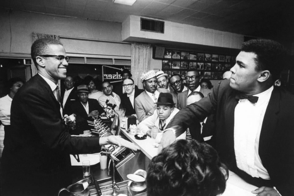 Image: Black Muslim leader Malcolm X, behind soda fountain, with  Muhammad Ali, while surrounded by jubilant fans after he beat Sonny Liston for the heavyweight championship of the world, March, 1964, in Miami, Florida. (Bob Gomel / The LIFE Images Collection/Getty)