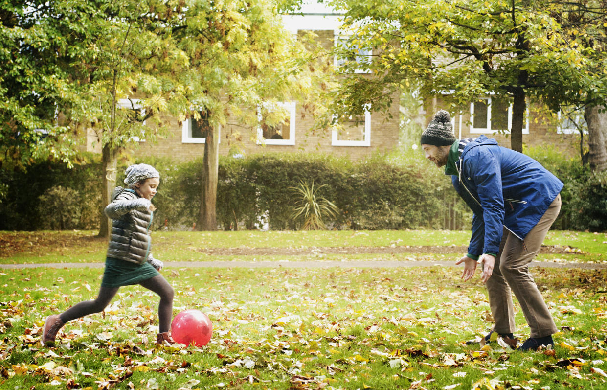 A young girl prepares to kick a ball