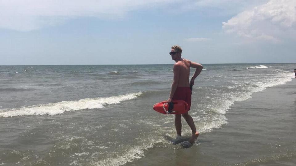 A lifeguard with Hilton Head Shore Beach Services monitors the water after a shark was spotted Thursday afternoon.