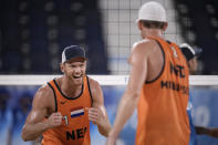 Alexander Brouwer, left, of the Netherlands, celebrates with teammate Robert Meeuwsen after winning a men's beach volleyball match against Argentina at the 2020 Summer Olympics, Tuesday, July 27, 2021, in Tokyo, Japan. (AP Photo/Felipe Dana)