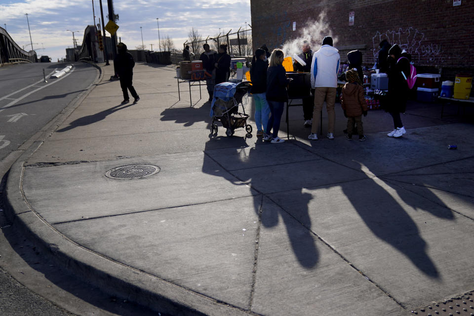 Steam rises in the cold air as a man serves soup across the street from an immigrant shelter in the Pilsen neighborhood of Chicago, Tuesday, Dec. 19, 2023. The death of a 5-year-old migrant boy and reported illnesses in other children living at the shelter has raised concerns about the living conditions and medical care provided for asylum-seekers arriving in Chicago. Four more people living in the same shelter — mostly children — were hospitalized with fevers this week. (AP Photo/Charles Rex Arbogast)