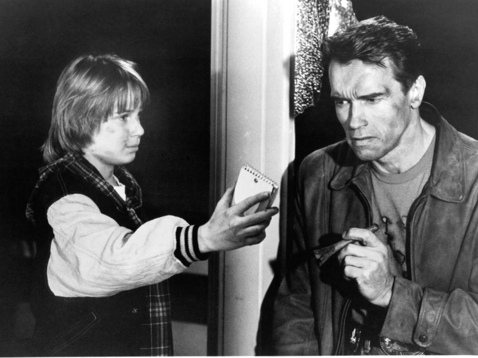 Austin O'Brien tries to prove to Arnold Schwarzenegger that they are really in a movie in a scene from the film, "Last Action Hero."