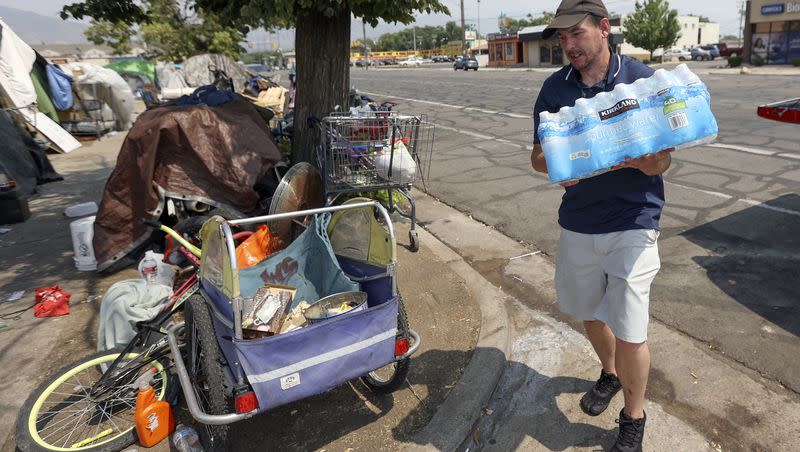 Ed Bluemel delivers a case of water to a homeless camp on 800 South during a heat wave in Salt Lake City on July 12, 2021. Bluemel and his brother, Cory Bluemel, raised over $700 to deliver ice, beverages and snacks to the homeless.