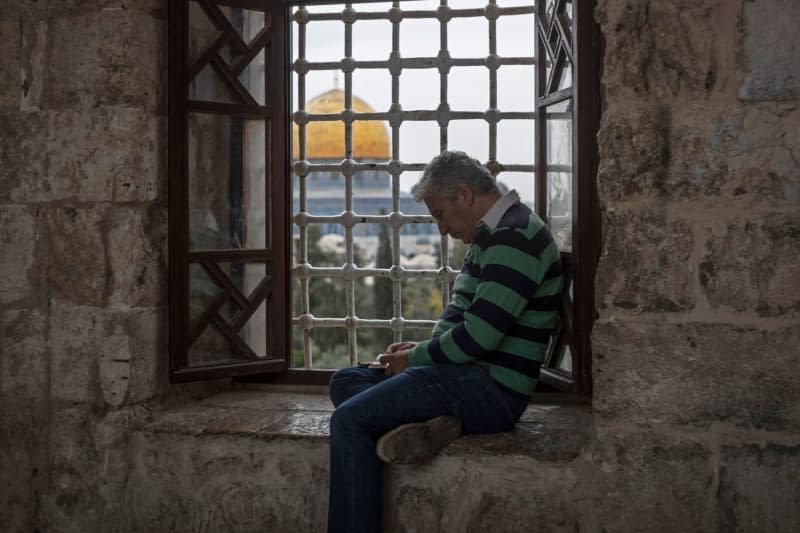 A man sits behind a window overlooking the Dome of the Rock mosque in Jerusalem's Al-Aqsa mosque compound, during the 3rd Friday of the Muslim's holy fasting month of Ramadan. Ilia Yefimovich/dpa