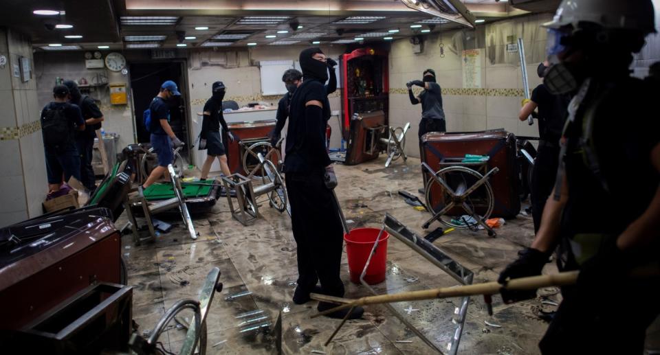 Pro-democracy protesters break into shops in the Tsuen Wan district, in Hong Kong on October 2, 2019. - Flash-mob rallies broke out in Hong Kong on October 2 as anger mounted over police shooting a teenage protester who attacked officers in a dramatic escalation of the violent unrest that has engulfed the territory for months. (Photo by NICOLAS ASFOURI / AFP) (Photo by NICOLAS ASFOURI/AFP via Getty Images)